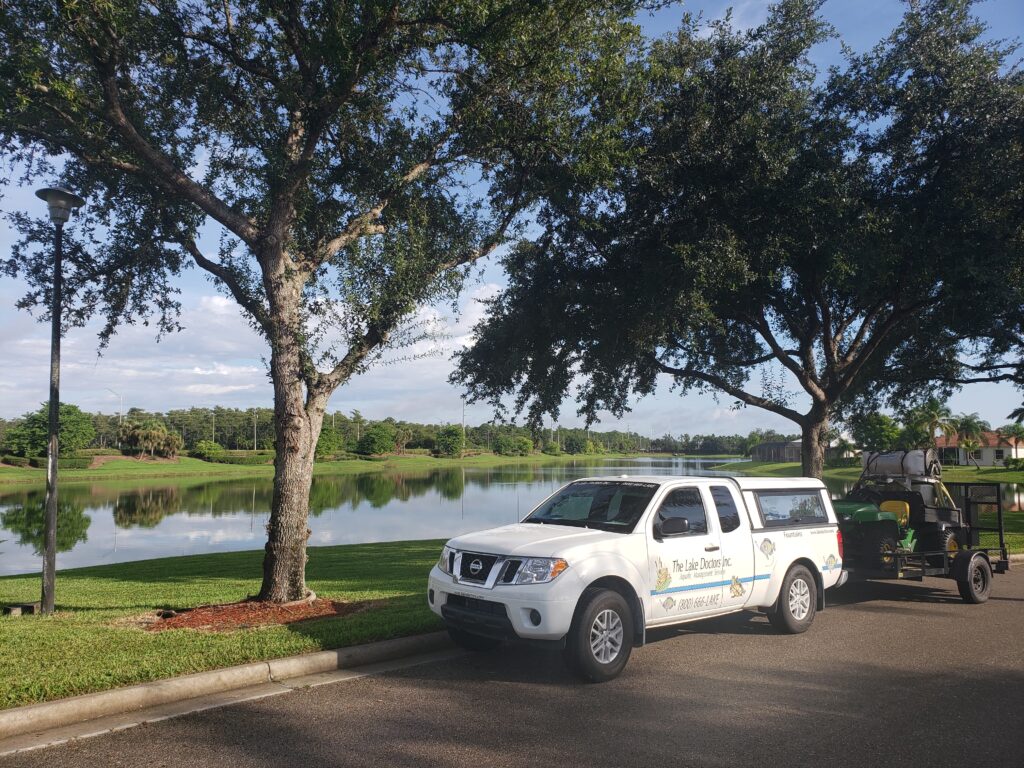 A Lake Doctors, Inc. truck parked next to a large lake.