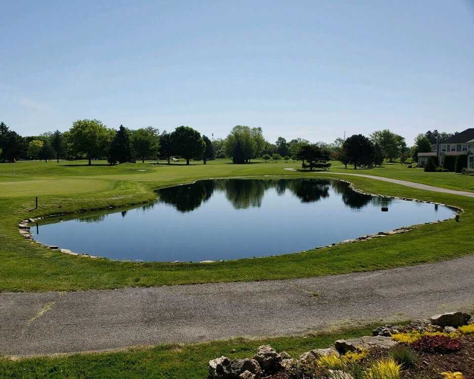 A clean, scenic lake on a golf course.