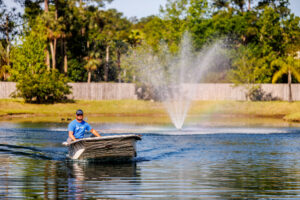 Man drives into a lake in a boat with a large fountain.